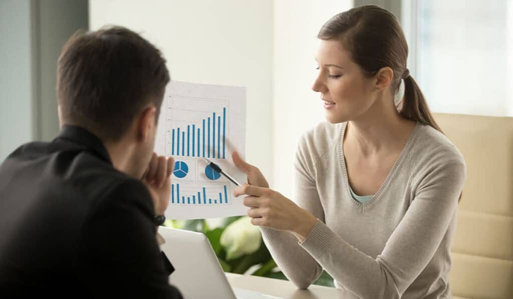 A woman, who is a property manager, showing man charts and graphs