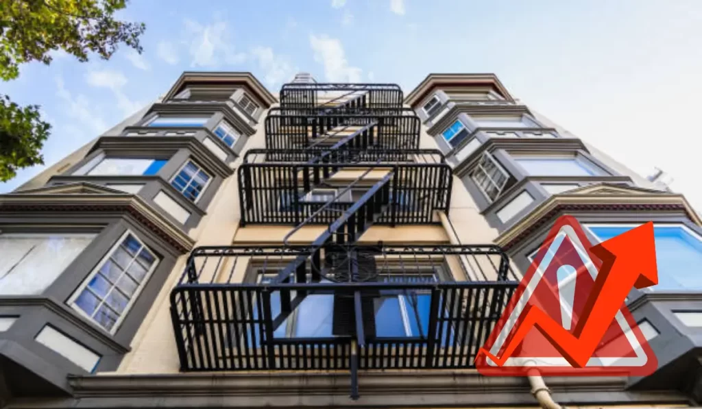 Upward view of an apartment with fire escapes, representing rent control California and rising rental prices.