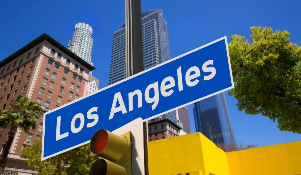 Street sign reading Los Angeles with city skyline in the background, representing a top market for real estate investors and long-term rental growth in 2025.
