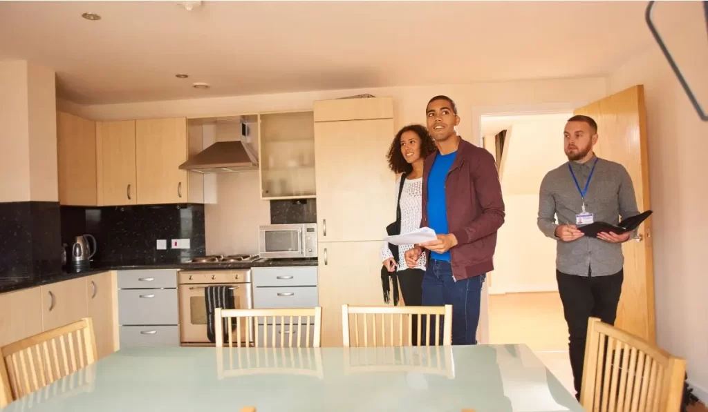 First-time tenants in Los Angeles during a property inspection walkthrough with a property manager inside a rental unit, reviewing checklist before lease signing.