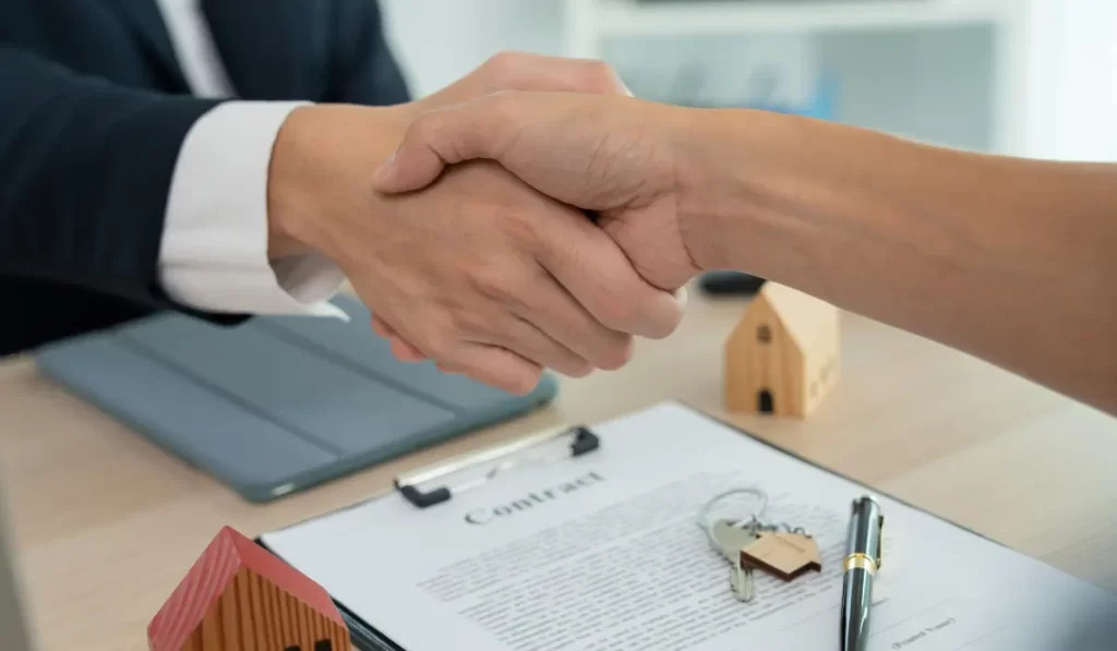 Property management companies finalizing rental contracts with landlords through handshake and signed agreement with house keys.