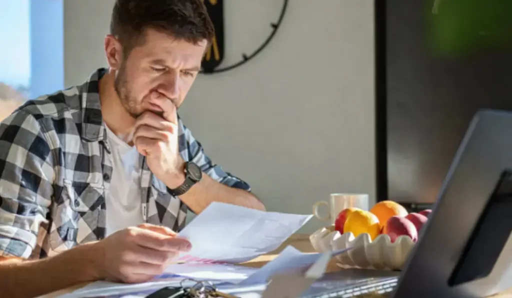Tenant Breaks the Lease landlord reviewing documents with keys after unexpected tenant move out situation.