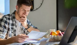 Tenant Breaks the Lease landlord reviewing documents with keys after unexpected tenant move out situation.